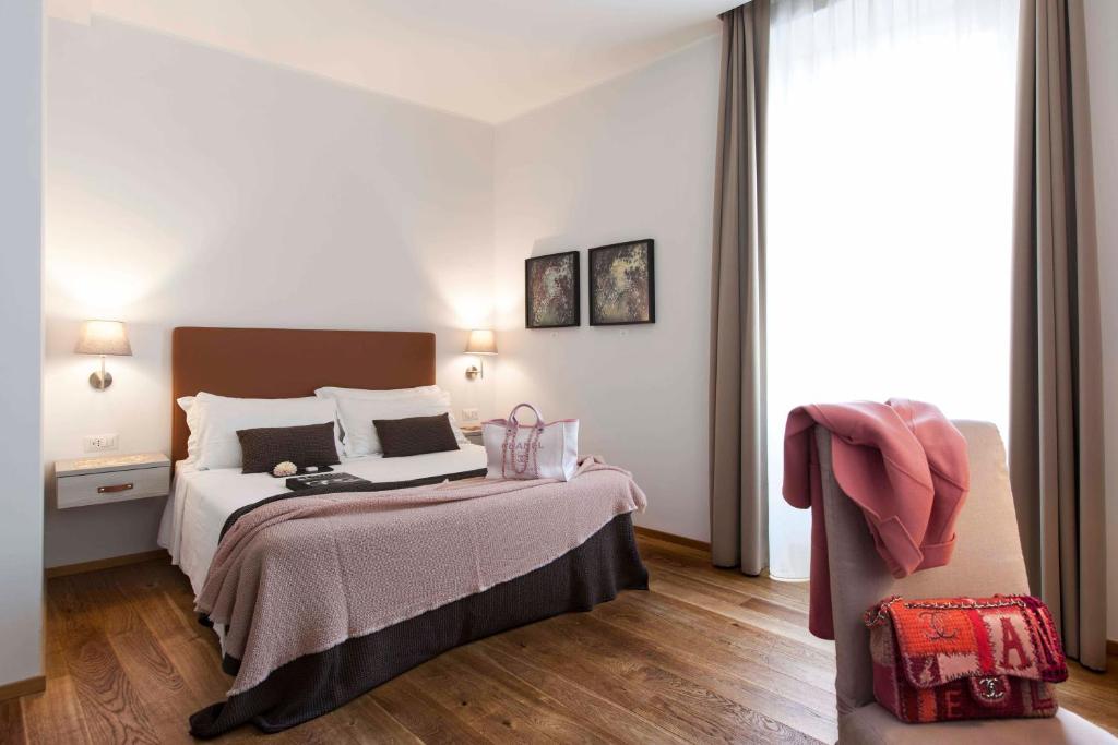 ローマにあるジュトゥルナ ブティック ホテルのベッドと椅子付きのホテルルーム