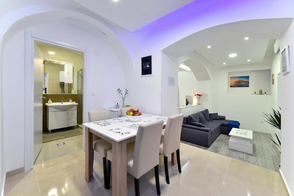 een keuken en een woonkamer met een tafel en een bank bij Apartment Frenki- Tkalčićeva -self check in- in Zagreb