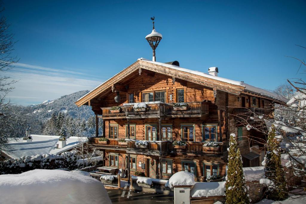 a log cabin in the snow with a tower at Buccara Apartments Kitzbühel in Kitzbühel