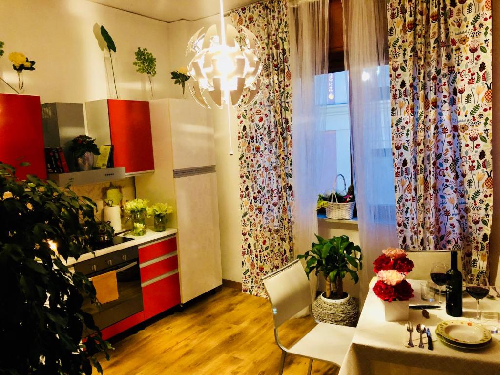 una cucina con armadi rossi, un tavolo e una sala da pranzo di Corso 126 Guest House Salerno a Salerno