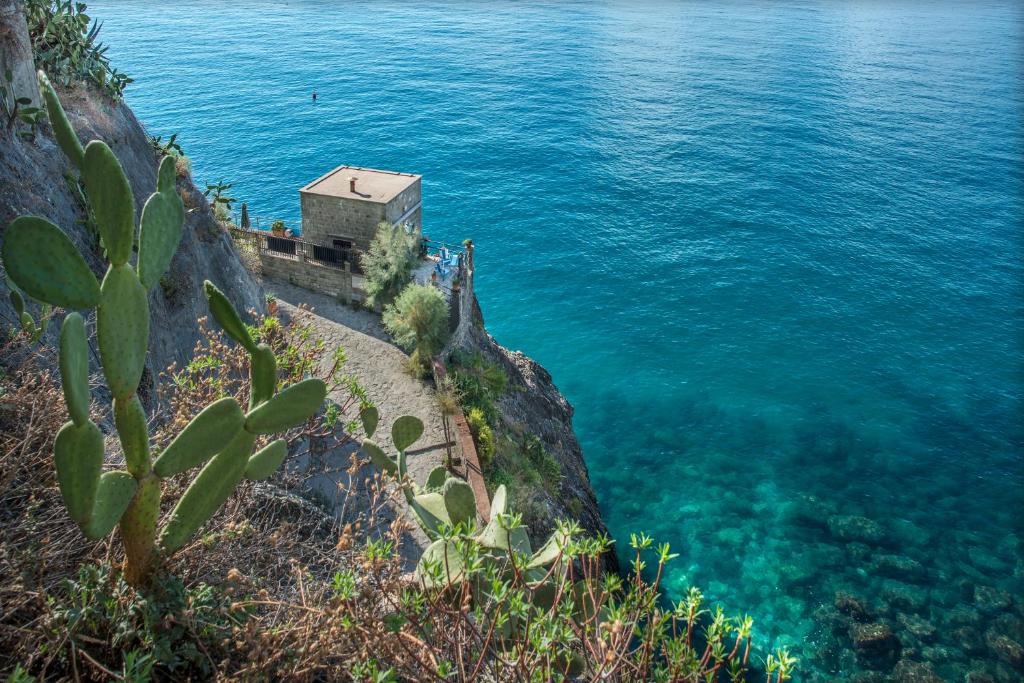 a house on a cliff next to the water at La Casa Del Doganiere in Monterosso al Mare