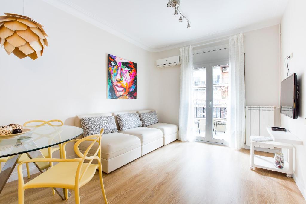 a white living room with a white couch and a table at Barcelona Eixample in Barcelona