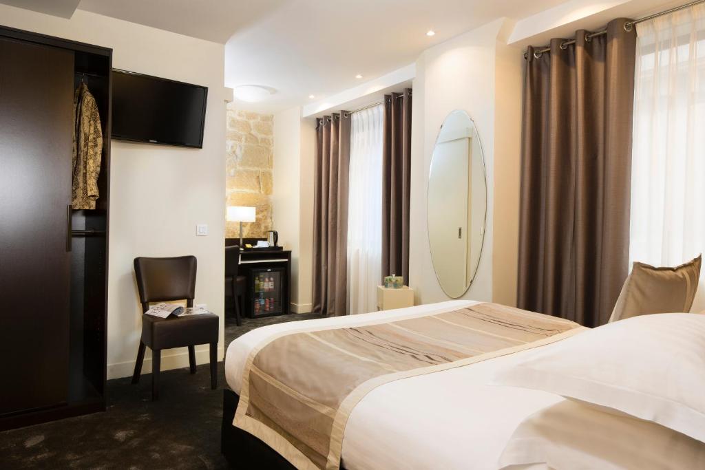 um quarto de hotel com uma cama e uma prancha de surf na parede em Hôtel du Lion d'Or Louvre em Paris