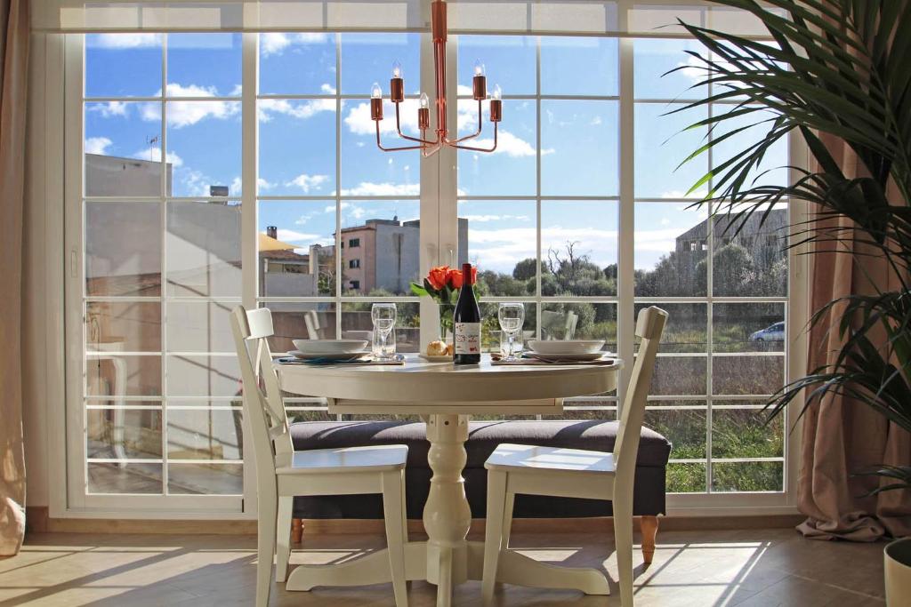 une salle à manger avec une table et des chaises devant une fenêtre dans l'établissement Apartamento Vacacions Felanitx, à Felanitx