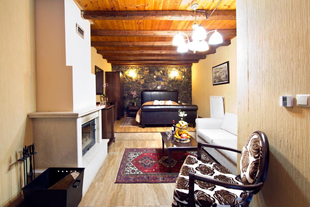 a living room with a bed and a fireplace at Chalet Lithos in Palaios Agios Athanasios