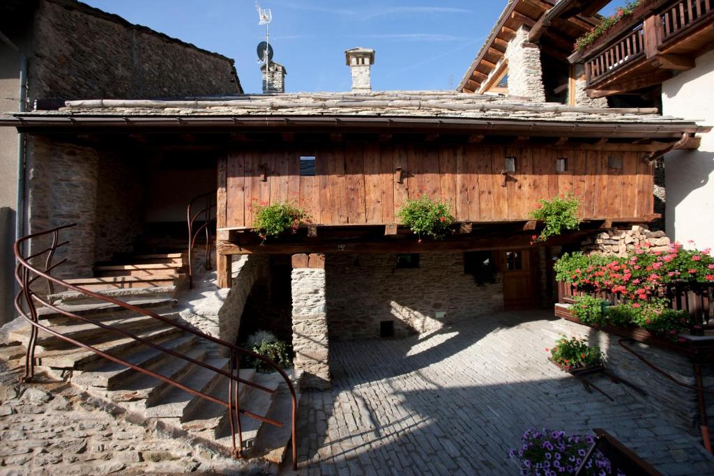 a building with a staircase and potted plants on it at Il Fienile della Nonna in Introd