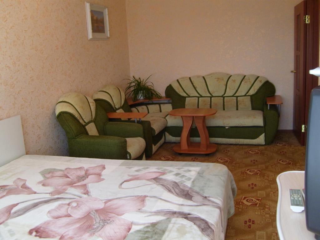 Krasnotur'inskにあるПопова 66のリビングルーム(椅子、ベッド、テーブル付)