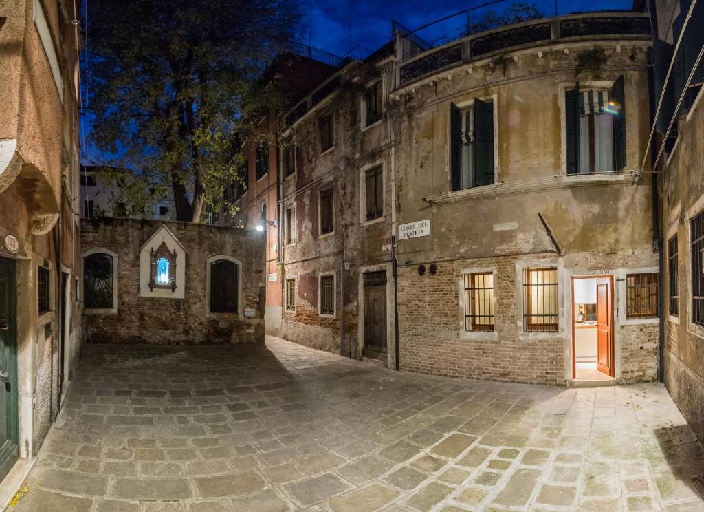 une allée vide dans un vieux bâtiment la nuit dans l'établissement Nike Appartamenti, à Venise