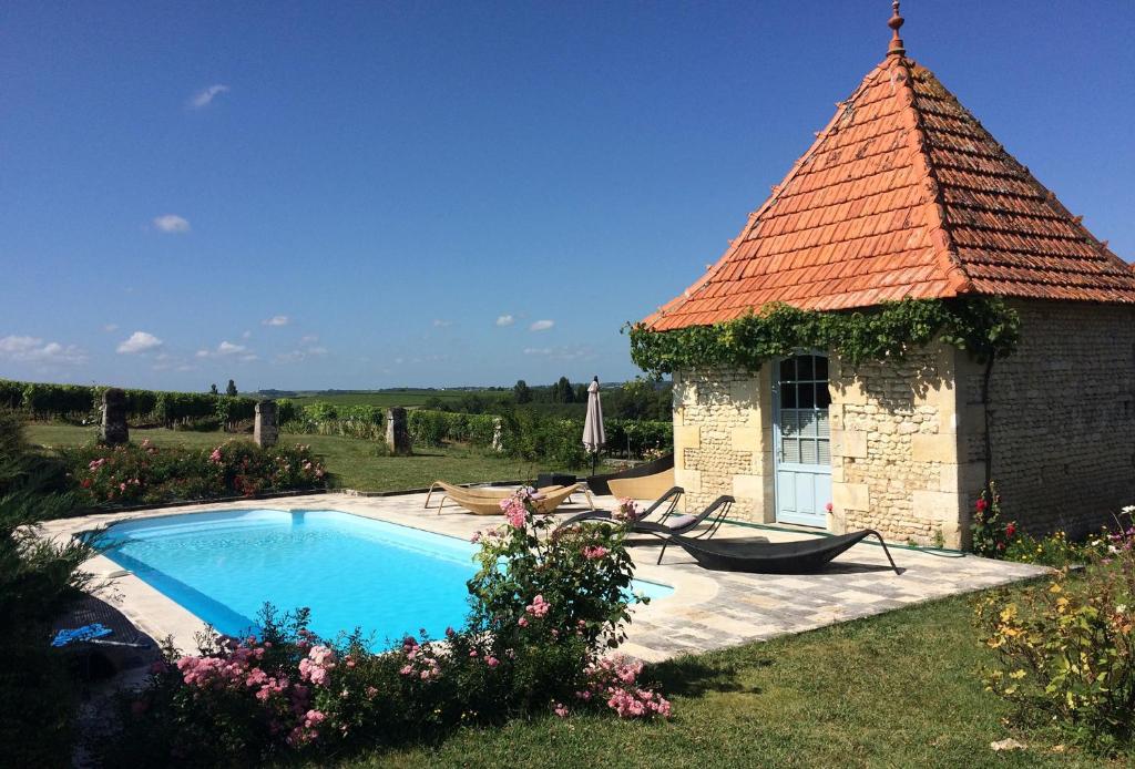 una casa con piscina en un patio en Chambre d'Hôtes Clos des Pierres Blanches, en Brie-sous-Archiac