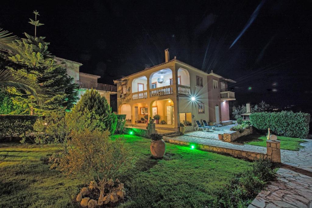 una casa grande por la noche con luces verdes en Mertoula House en Zakynthos