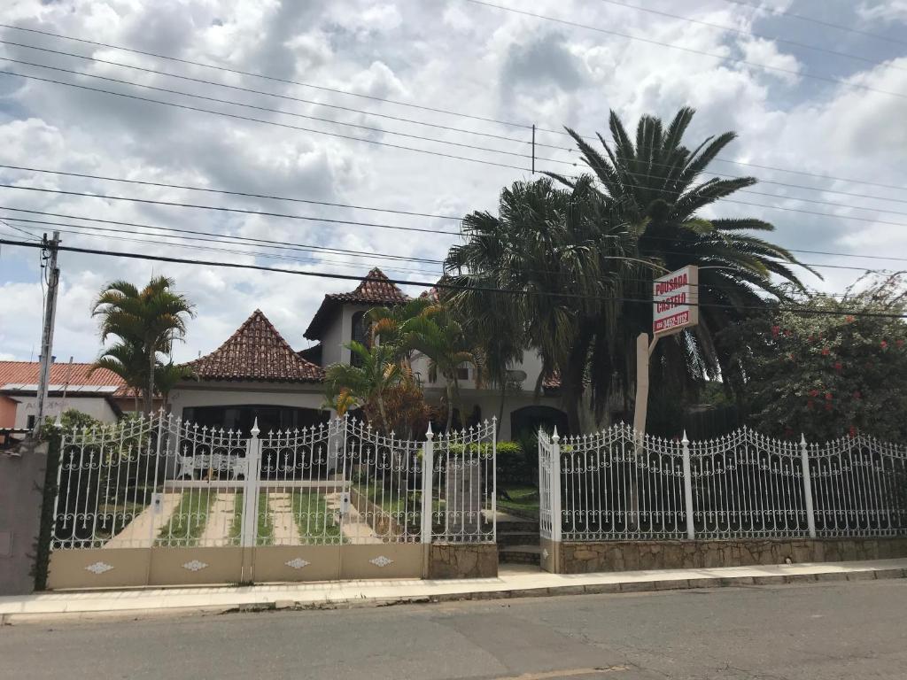 a white fence in front of a house at Pousada Castelo in Careaçu