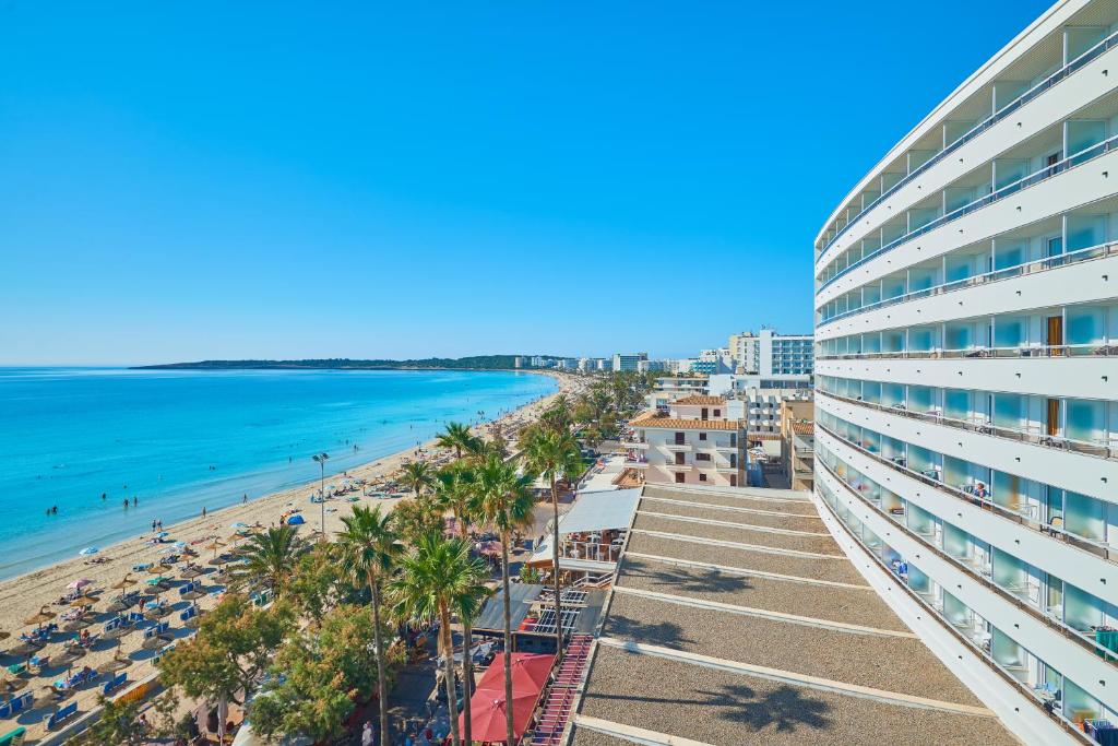 - une vue sur la plage depuis le balcon d'un bâtiment dans l'établissement Hipotels Don Juan, à Cala Millor