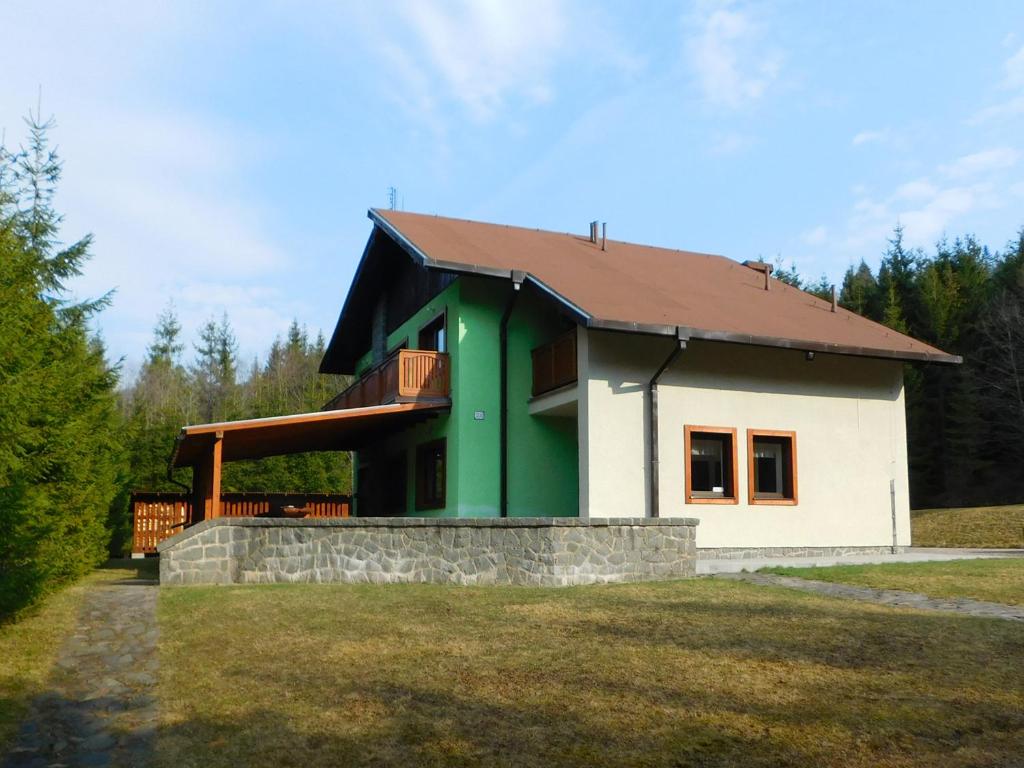 uma pequena casa com um verde e branco em Poľovnícka chata Štefana em Mlynky 