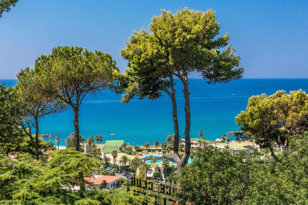 a view of a resort with trees and the ocean at Club Residence La Castellana in Belvedere Marittimo