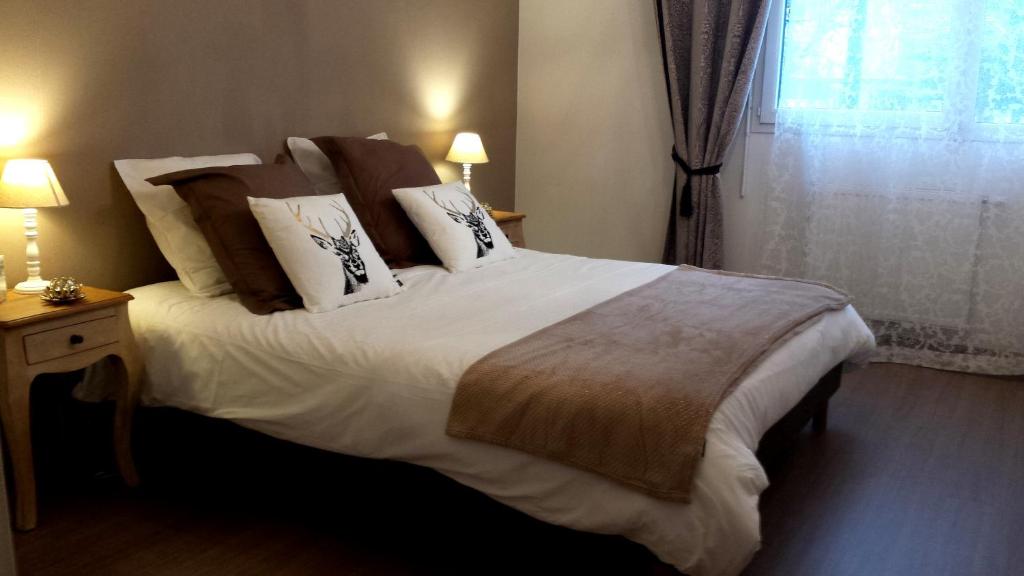 una camera da letto con un grande letto con lenzuola e cuscini bianchi di Le janua - Accort ad Annecy