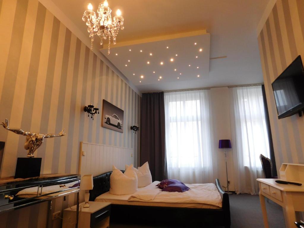 een hotelkamer met een bed en een kroonluchter bij Boutiquehotel Mason in Altenburg