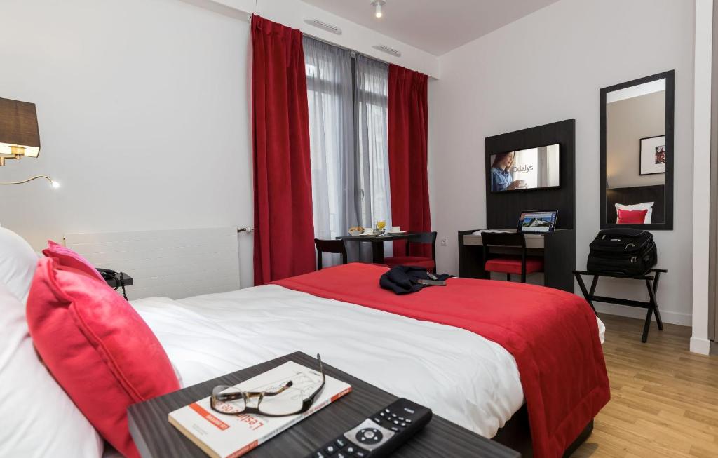 a hotel room with two beds and a television at Odalys City Paris Montmartre in Paris