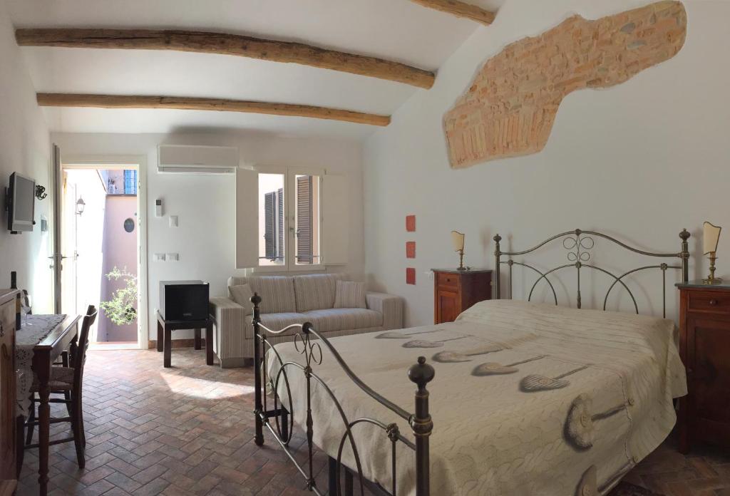a bedroom with a bed and a living room at La Casetta nel Borgo in Faenza