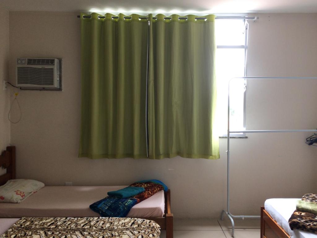 1 dormitorio con cortina verde y ventana en Pousada terraco Rio Centro, en Río de Janeiro