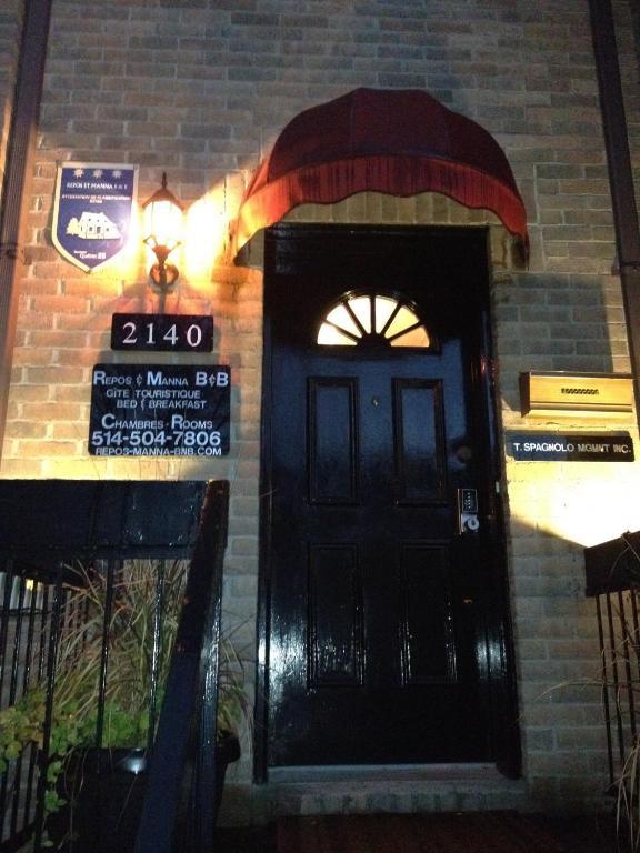 a black door with a sign on a brick building at Repos & Manna Downtown Montréal in Montreal