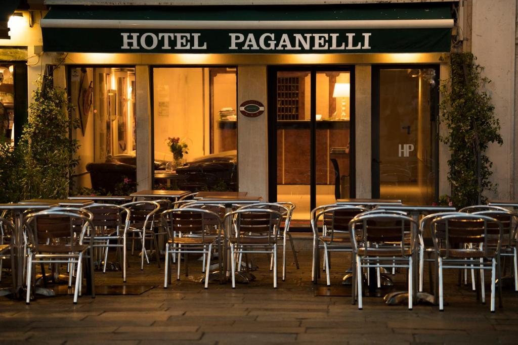 a group of tables and chairs in front of a hotel restaurant at Hotel Paganelli in Venice