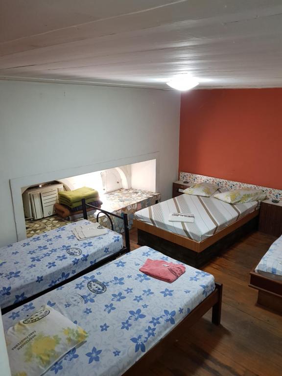 a room with three beds in it at Hotel Cabo Finisterra in Rio de Janeiro