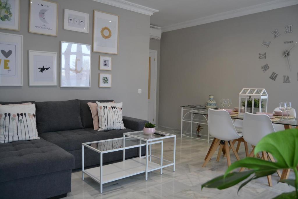 uma sala de estar com um sofá e uma mesa em Sherryflat Alcázar - Parking em Jerez de la Frontera