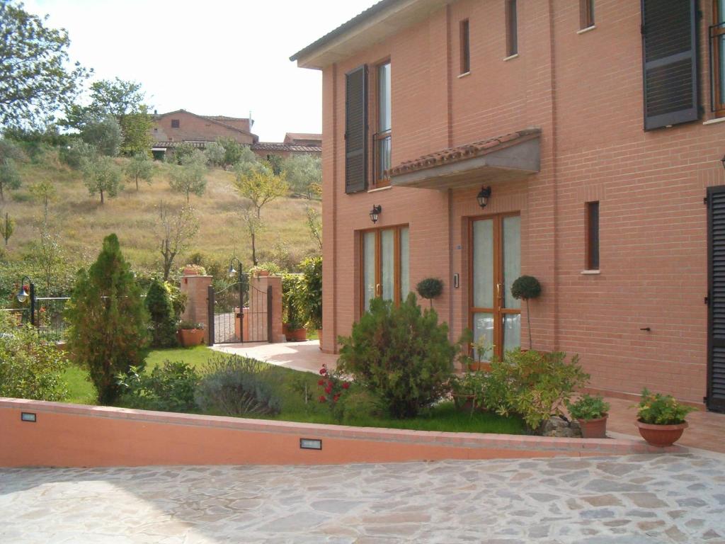 una casa de ladrillo con un jardín delante de ella en B&B La Verbena, en Siena
