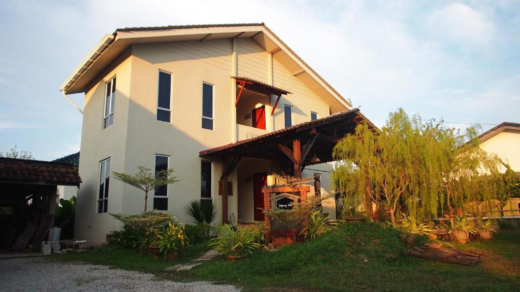 a large white house with a roof at Family Lodge 25 in Kota Bharu