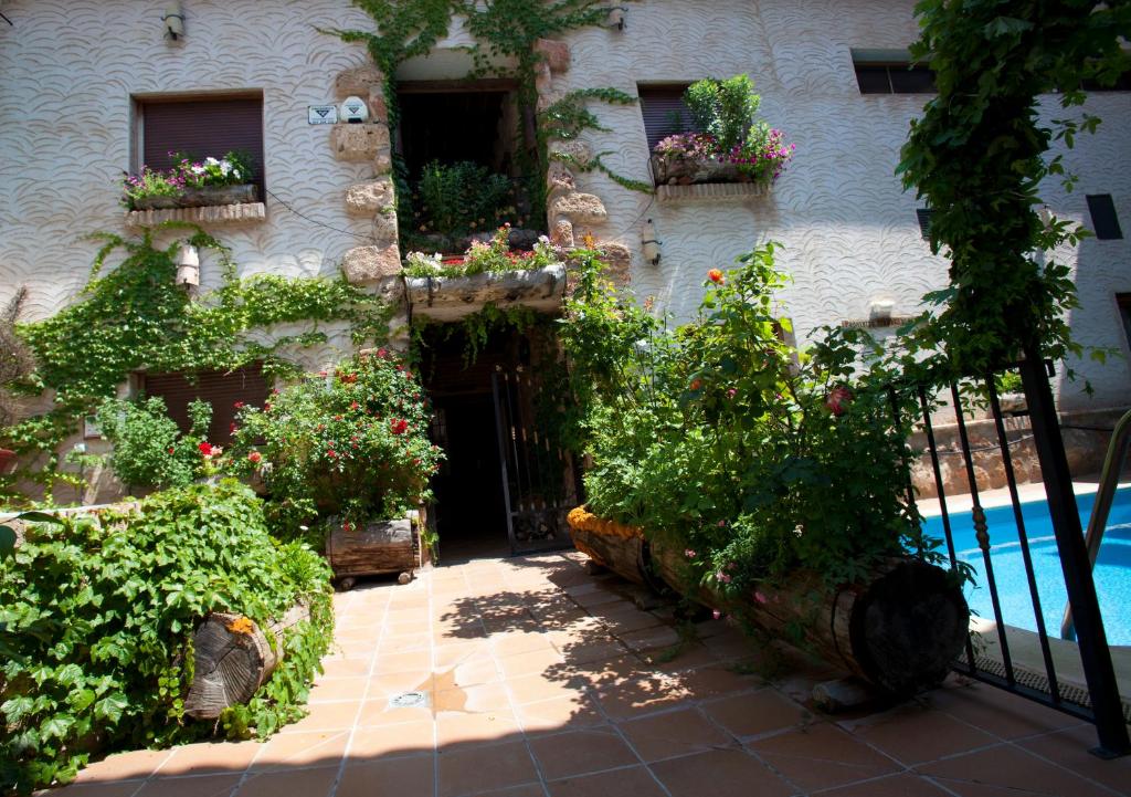 a house with a pool and some plants and a fence at Casa Rural Capricho del Valle in Arroyo Frio