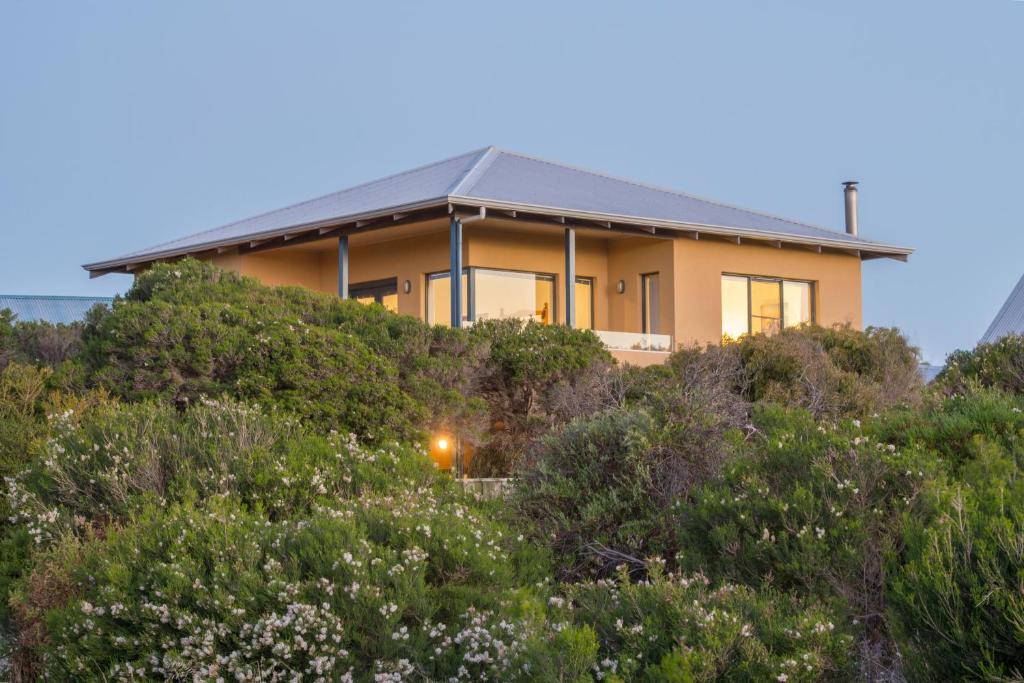 a house on top of a hill with bushes at Kilifi Beach House in Gnarabup