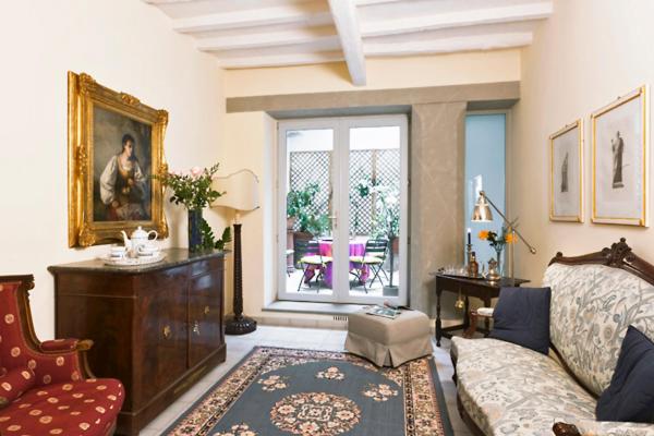 een woonkamer met een bank en een stoel bij Via dei Fossi apartment in Florence
