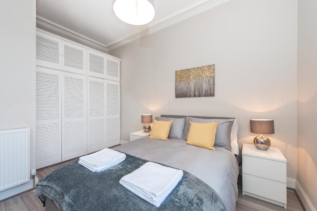 a bedroom with a large bed with yellow pillows at The New Westfield in Edinburgh