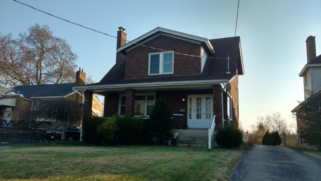 a brown brick house with a white door at Homestay in Westwood 97909 in Cincinnati