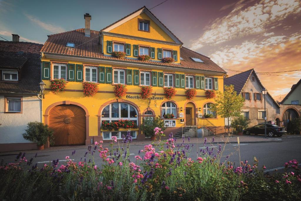 a yellow building with flowers in front of it at Weinhotel / Gasthaus zur Sonne in Ihringen