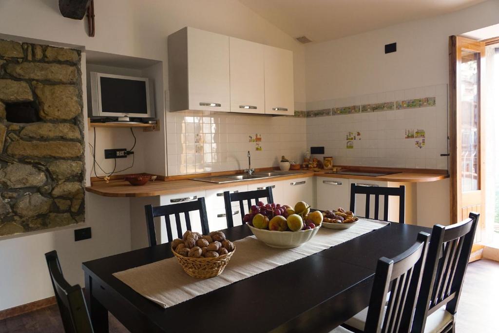 una cocina con una mesa con tazones de fruta. en Casa di Nonno Mariano, en Motta Camastra