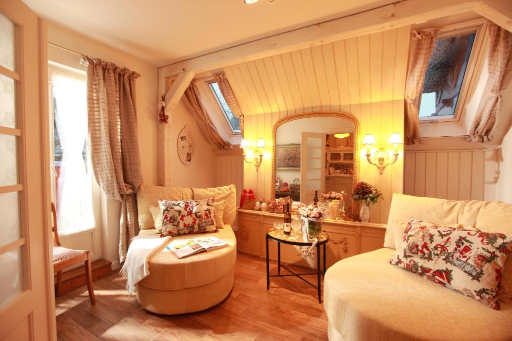 a living room with a couch and a mirror at Weißt Du noch - Gästehäuser & Suiten in Kühlungsborn