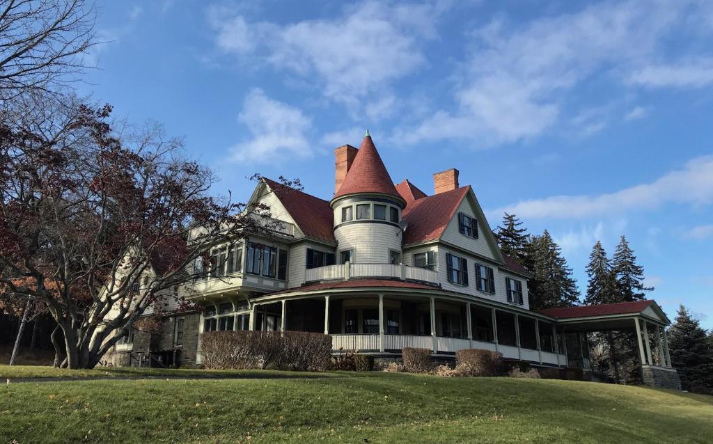 a large house with a turret on top of a hill at Idlwilde Inn in Watkins Glen