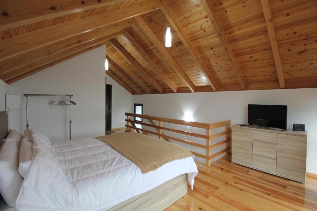 Schlafzimmer mit einem Bett und einem Flachbild-TV in der Unterkunft Refúgio da Xamusca in São Vicente