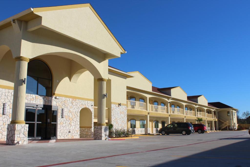 un edificio con un coche aparcado delante de él en Express Inn and Suites, en Humble