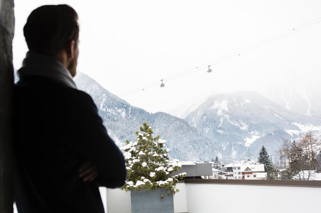 a man looking out of a window at a christmas tree at ElisabethHotel Premium Private Retreat- Adults only in Mayrhofen