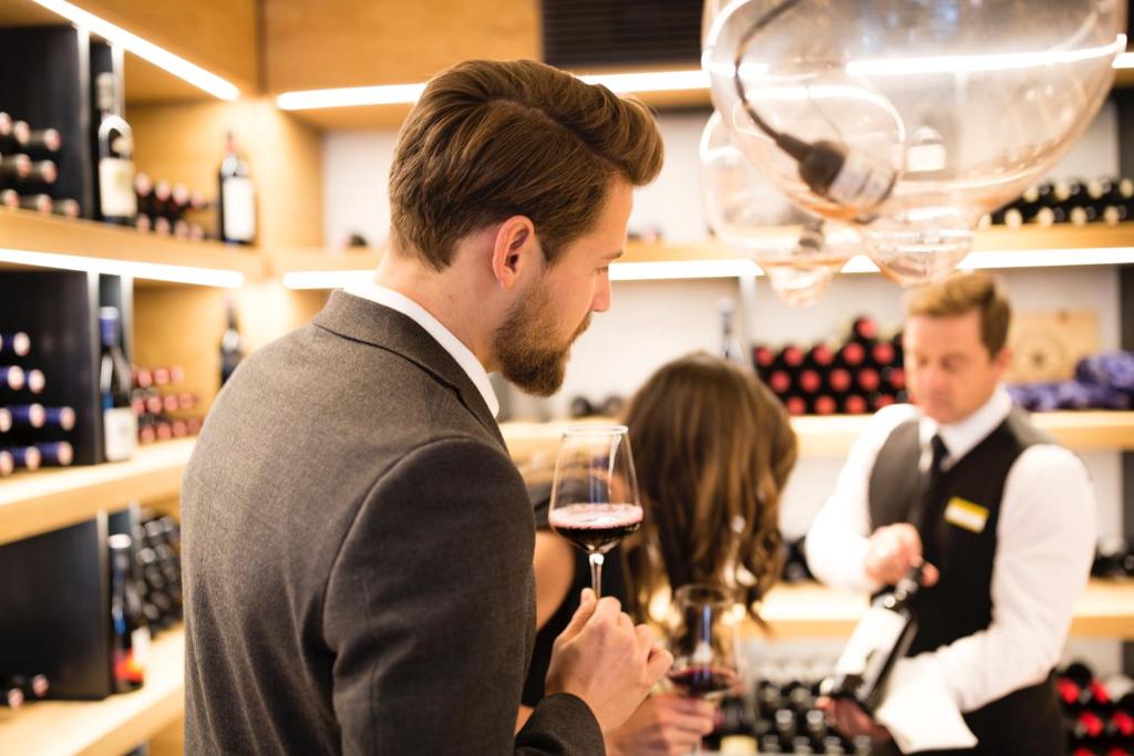 a man holding a glass of wine in a wine store at ElisabethHotel Premium Private Retreat- Adults only in Mayrhofen