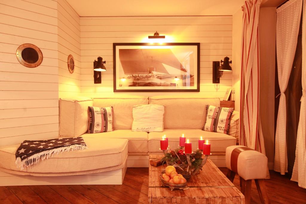 a living room with a couch and a table with candles at Weißt Du noch - Gästehäuser & Suiten in Kühlungsborn