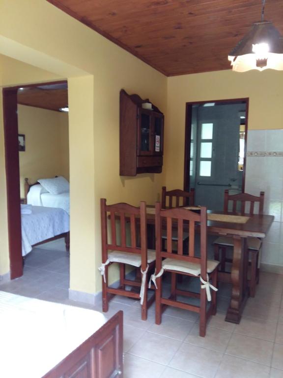 - une salle à manger avec une table, des chaises et un lit dans l'établissement Estancia Don Jose- GuenGuel, à Río Mayo