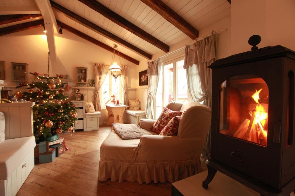 a living room with a fireplace and a christmas tree at Weißt Du noch - Gästehäuser & Suiten in Kühlungsborn