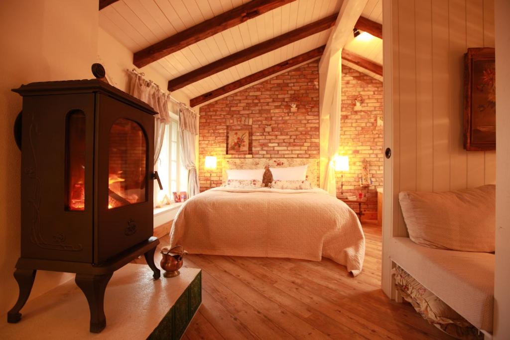 a bedroom with a bed and a wood stove at Weißt Du noch - Gästehäuser & Suiten in Kühlungsborn