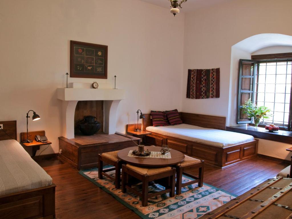 a living room with a bed and a table at Mansion Karagiannopoulou in Vizitsa