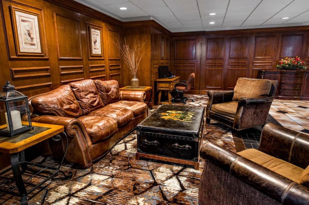 a living room filled with leather couches and chairs at Lodge of the Ozarks in Branson