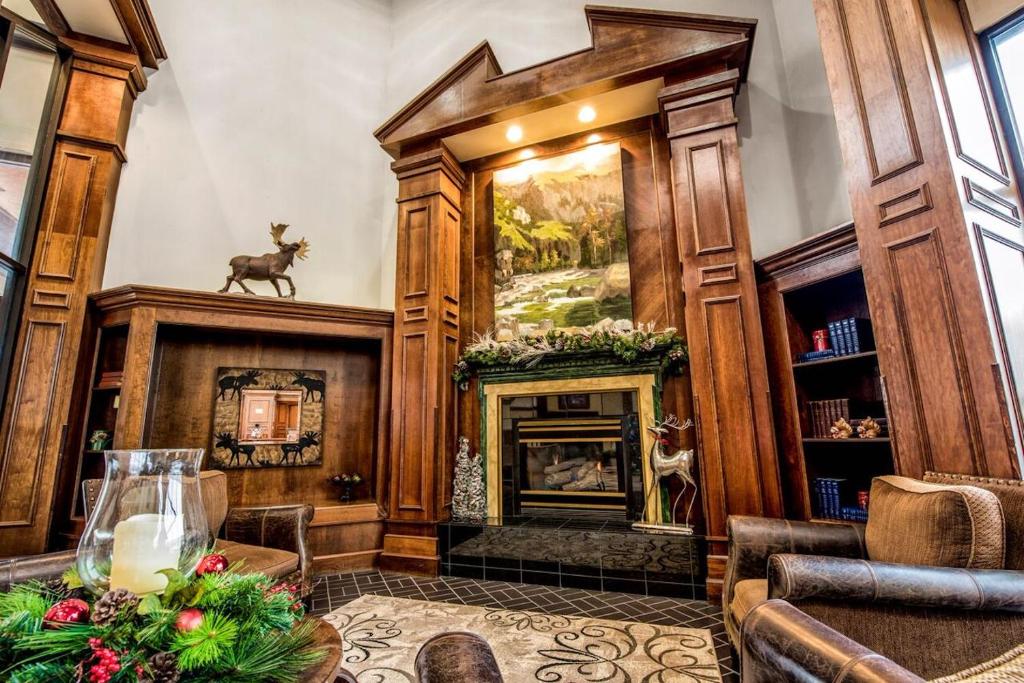 a living room with a fireplace and wooden walls at Lodge of the Ozarks in Branson