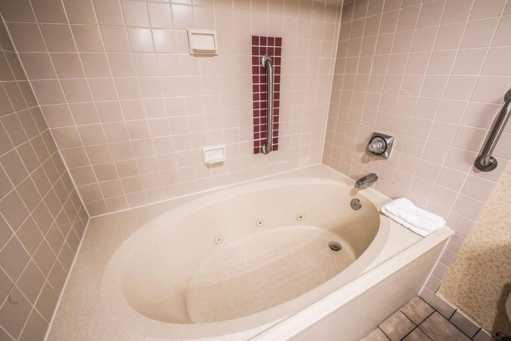 a bath tub in a bathroom with pink tiles at Lodge of the Ozarks in Branson